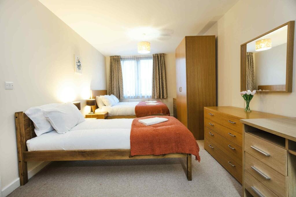 A bright and tidy double bedroom featuring two ...