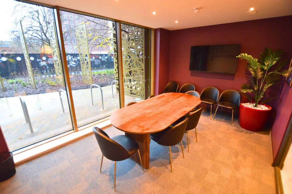 A modern communal workspace featuring a large w...