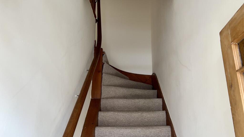 A carpeted staircase with wooden handrails on b...