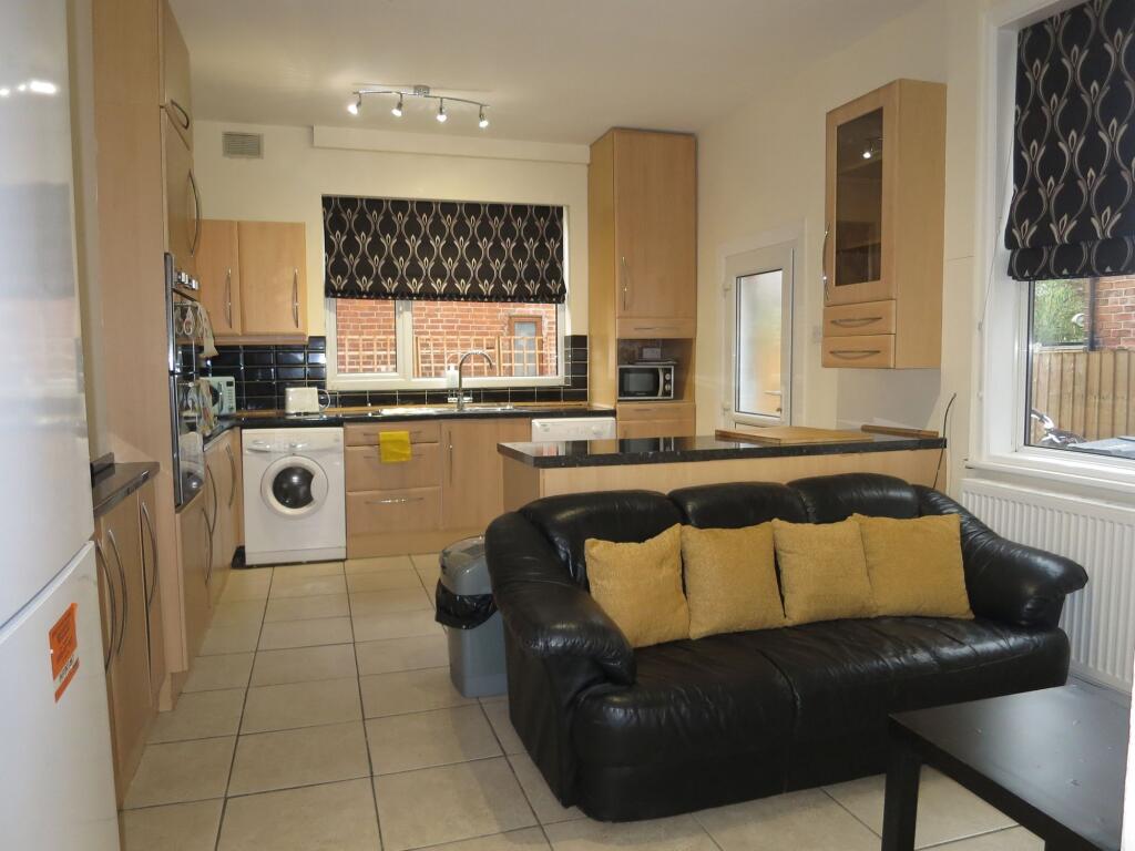 A modern kitchen with ample cabinetry, black co...