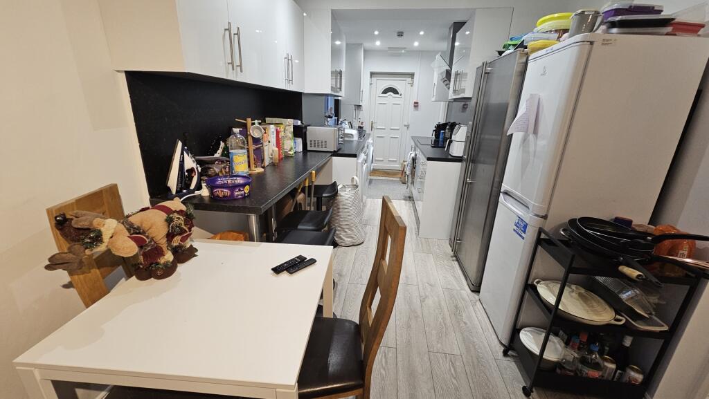A modern, well-equipped kitchen featuring white...
