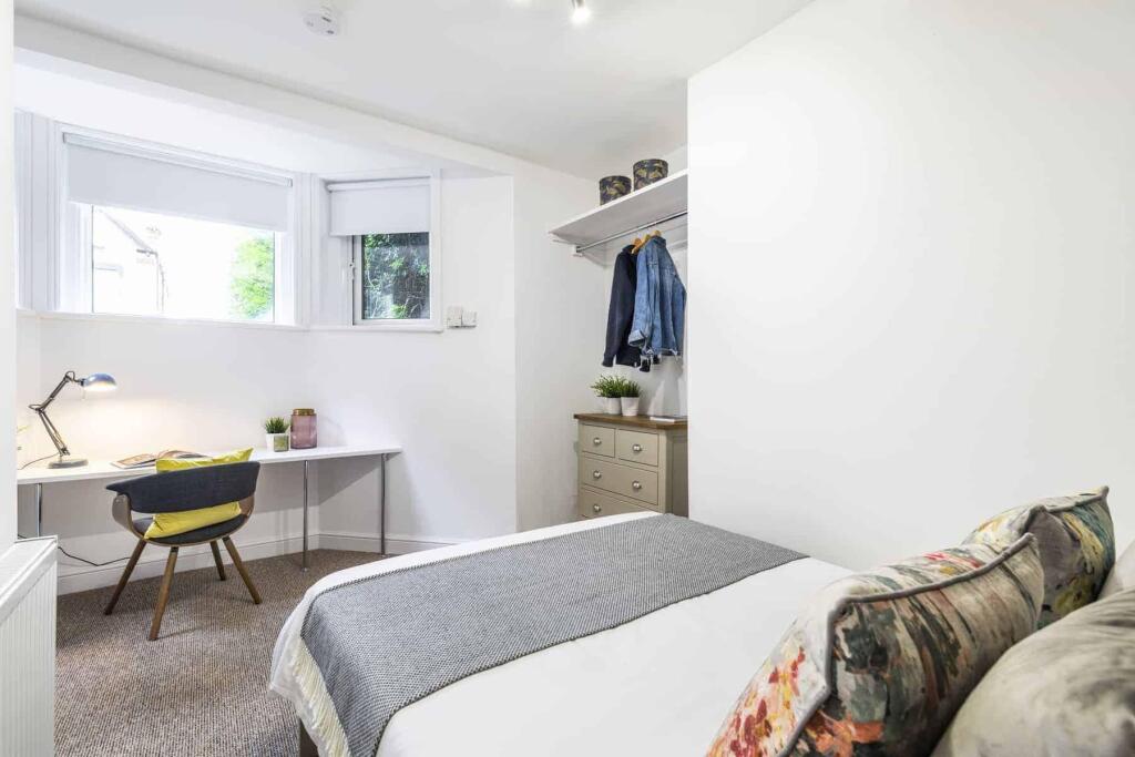 A bright and cozy bedroom featuring a comfortab...