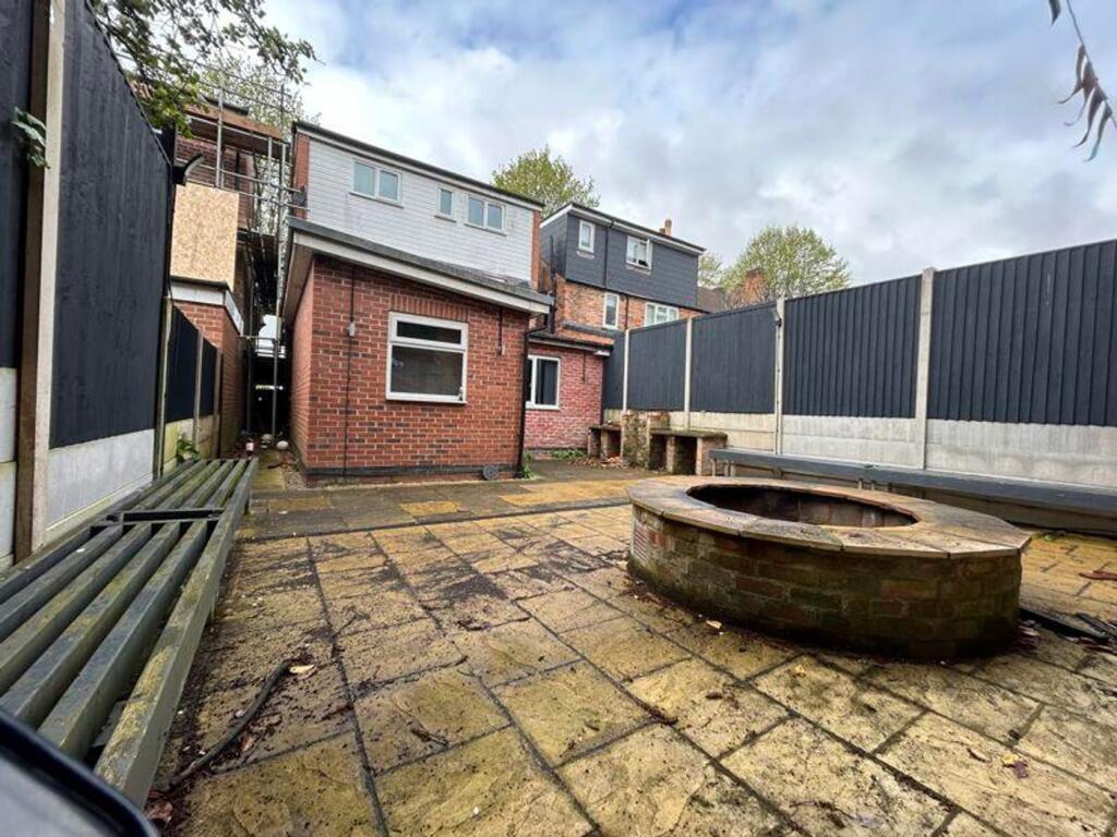 A spacious garden area with a unique stone fire...