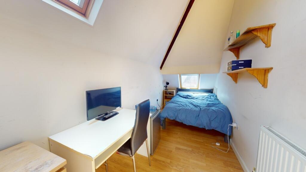 A cozy single bedroom featuring a comfortable b...