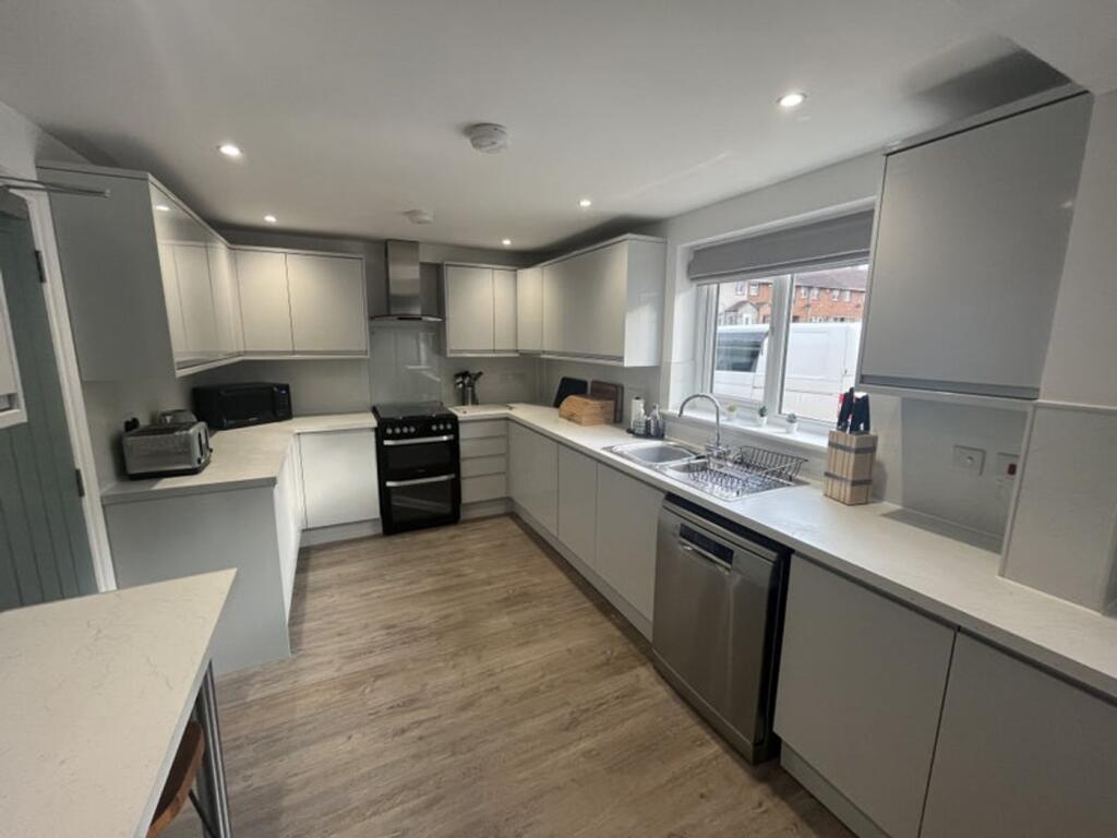 Modern and spacious kitchen featuring sleek cab...