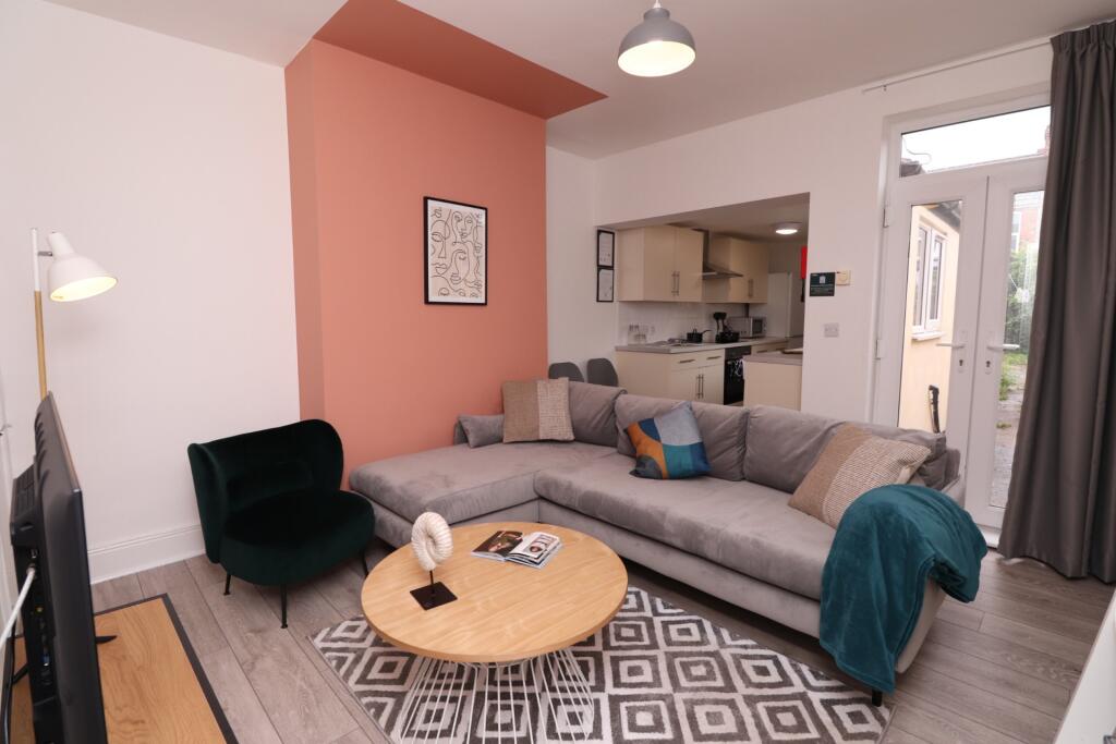 A spacious and inviting living room featuring a...