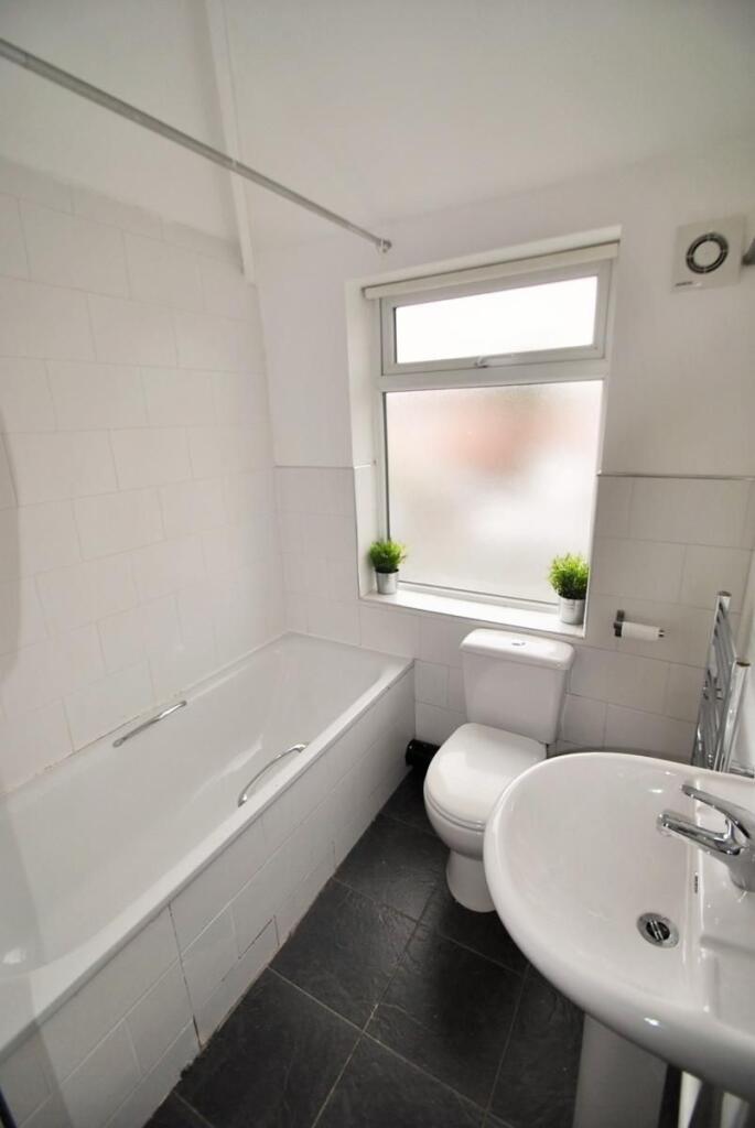 Bright and clean bathroom suite featuring a ful...