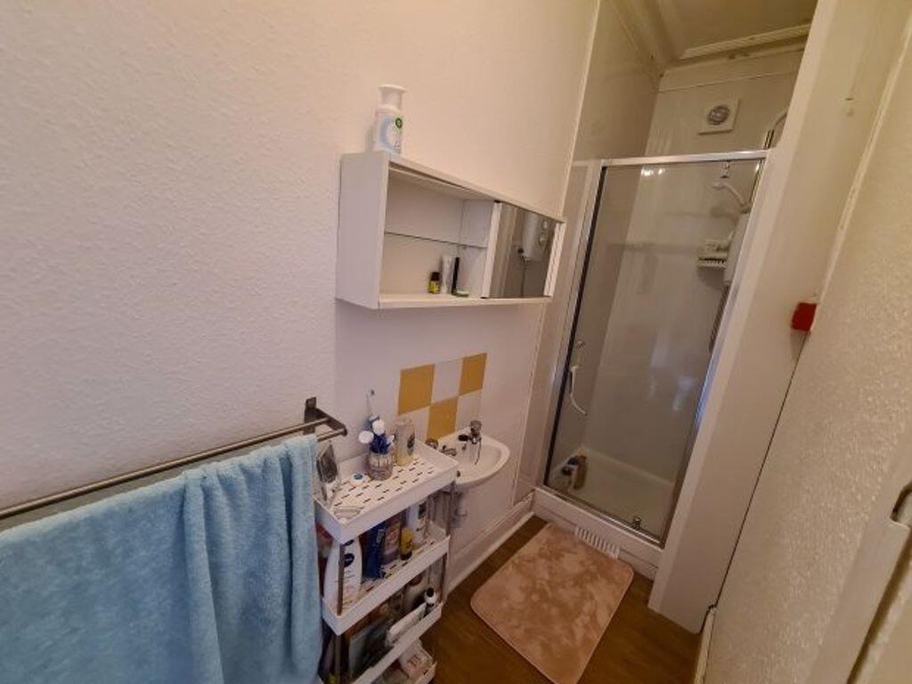 Compact, well-kept bathroom with a clear glass ...