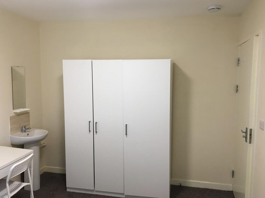 A neat and simple single bedroom featuring a wh...