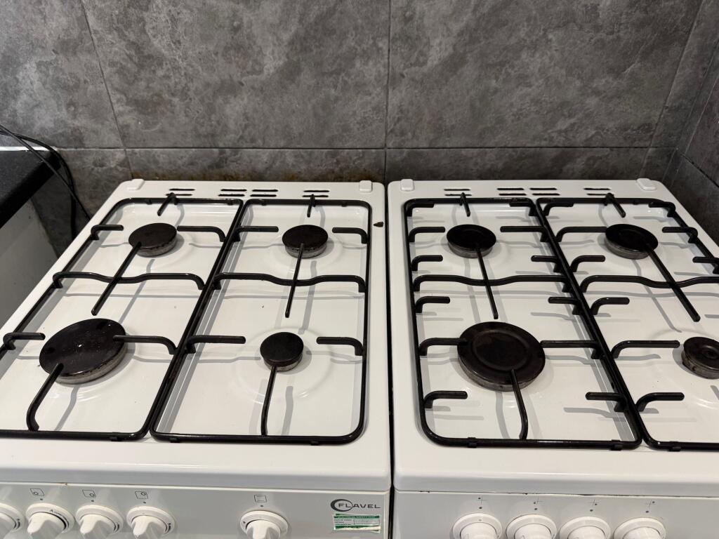 A clean twin gas hob setup with four burners on...