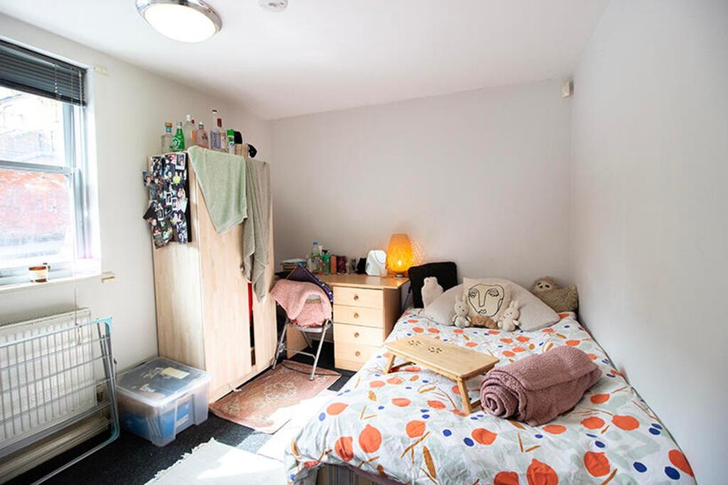 This cozy double bedroom features a warm ambian...