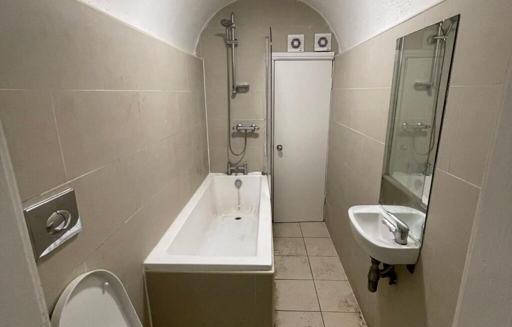 A compact bathroom suite featuring a bathtub wi...