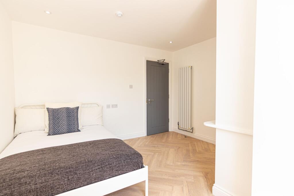 A bright and modern master bedroom featuring a ...
