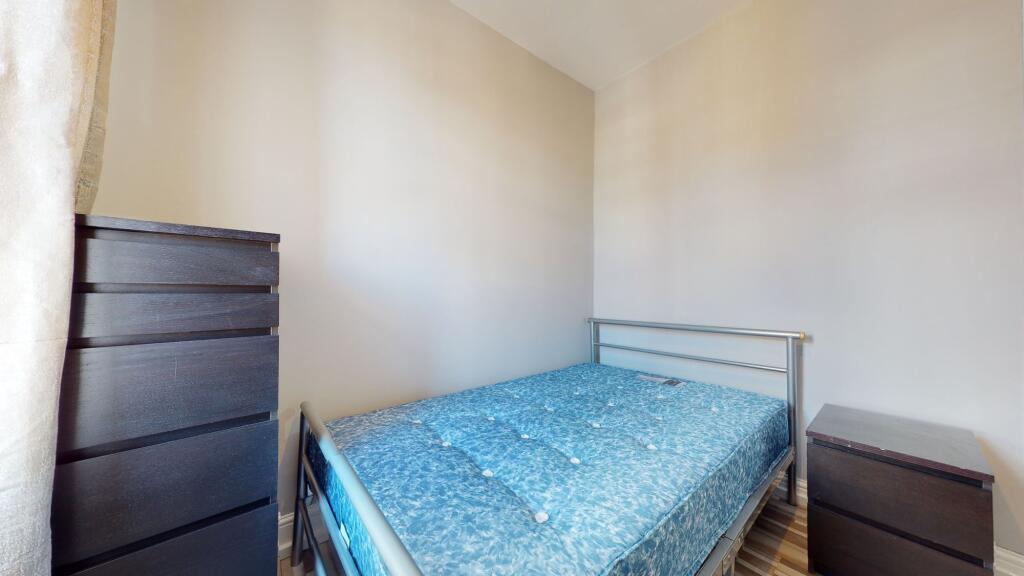 The room features a single bed with a metal fra...