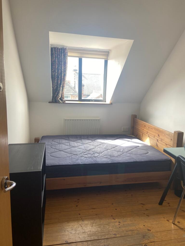 A spacious and inviting double bedroom with woo...