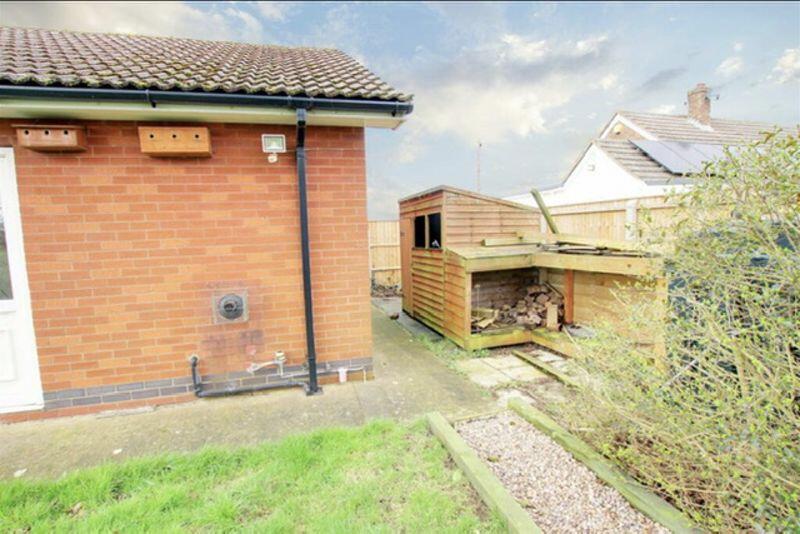 Small opposite side garden and log store