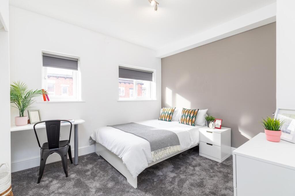 Bright, neatly styled double bedroom with a neu...