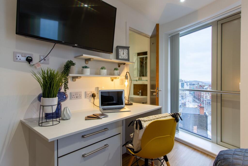 A modern double bedroom featuring a bright work...