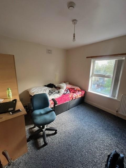 A cozy single bedroom featuring a single bed wi...
