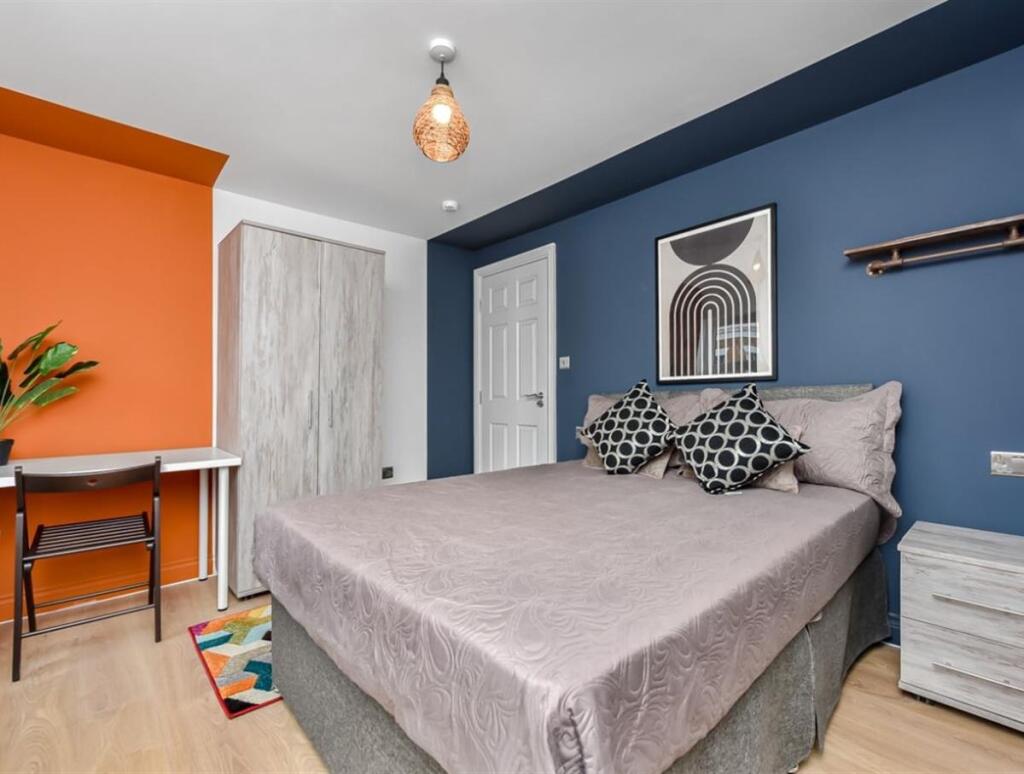 A modern bedroom featuring a comfortable double...