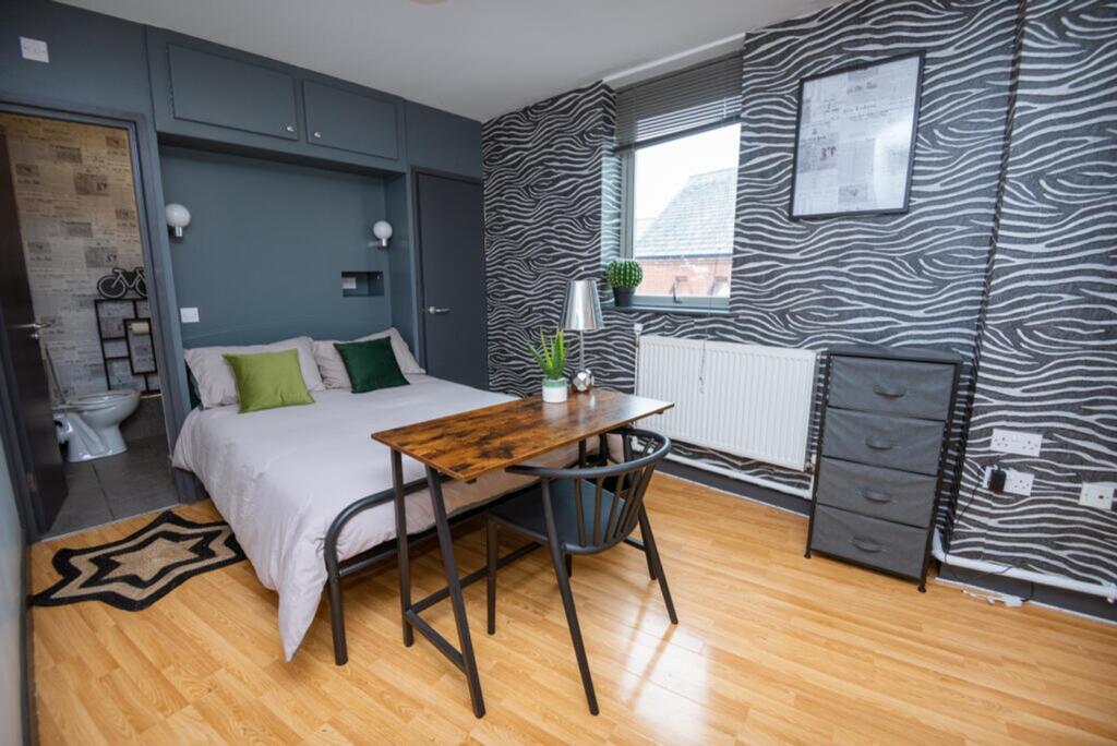 This stylish double bedroom features modern dec...