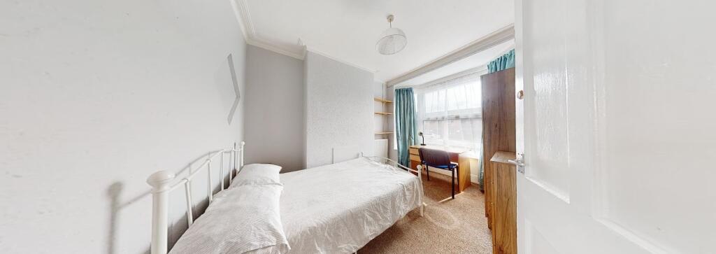 A tidy, well-lit single bedroom featuring a sin...