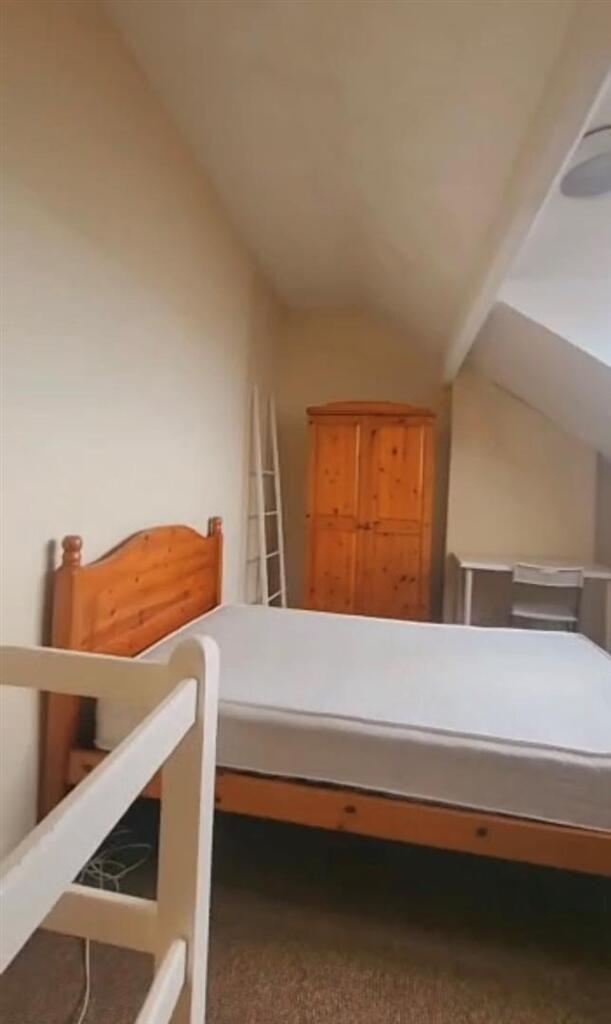 A neat and simple room with a wooden bed frame ...