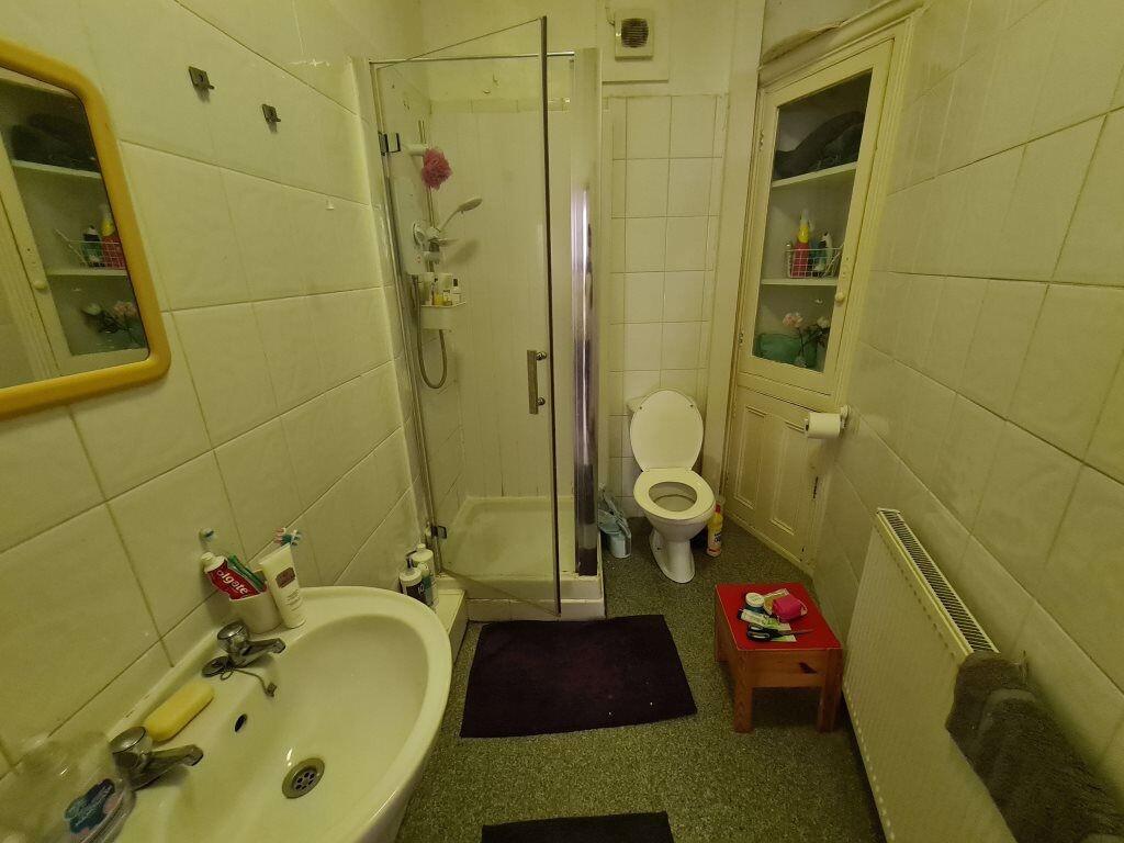 Well-maintained bathroom featuring a shower enc...