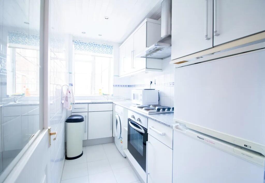 Bright and modern kitchen featuring white cabin...