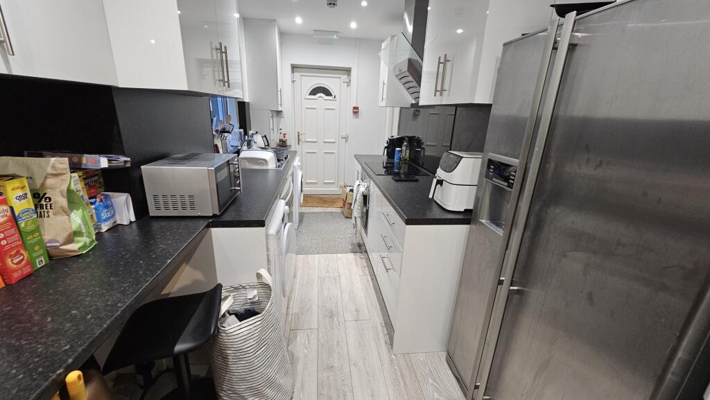 A modern, well-equipped kitchen with sleek whit...