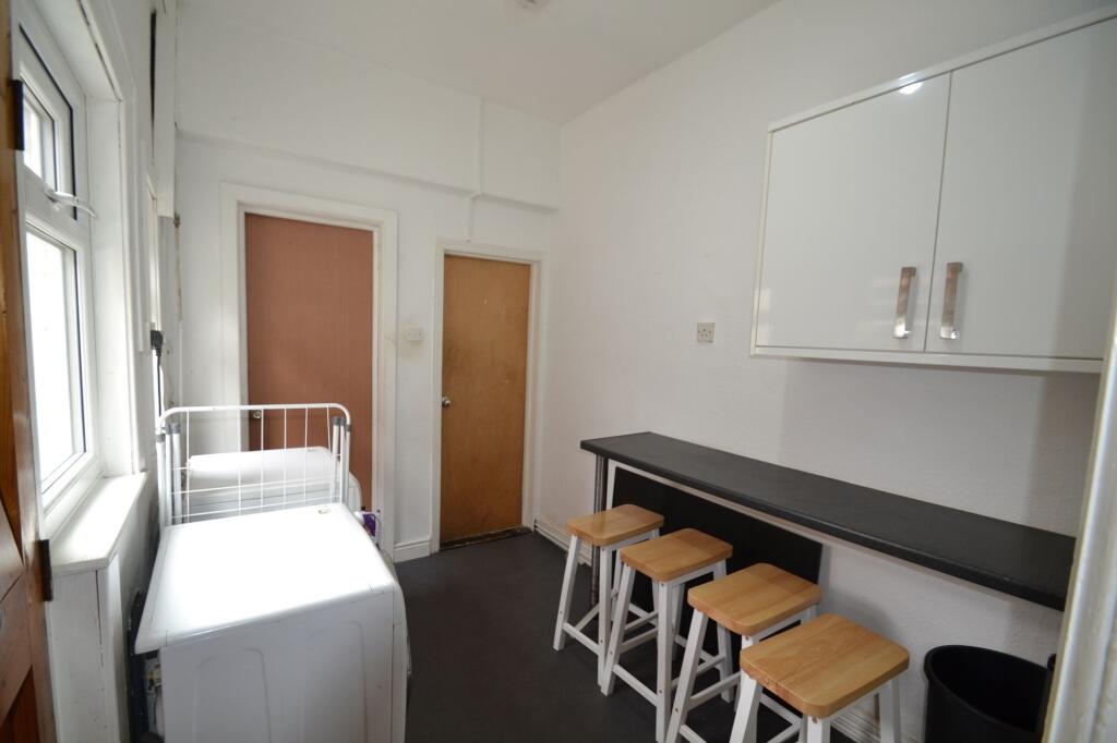 Bright kitchen area with a long black counterto...