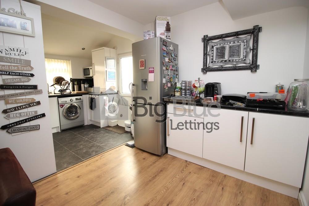 A modern kitchen area featuring light wood floo...