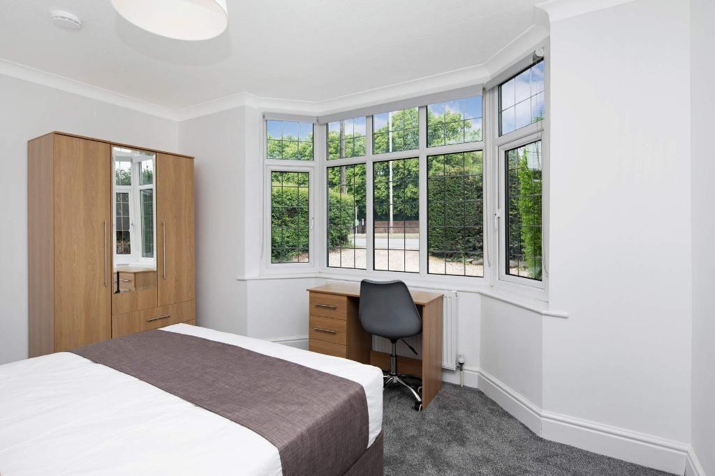 This inviting double bedroom features large win...