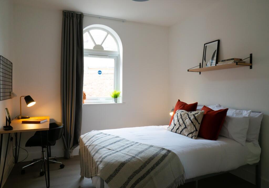 A bright and inviting double bedroom with a coz...