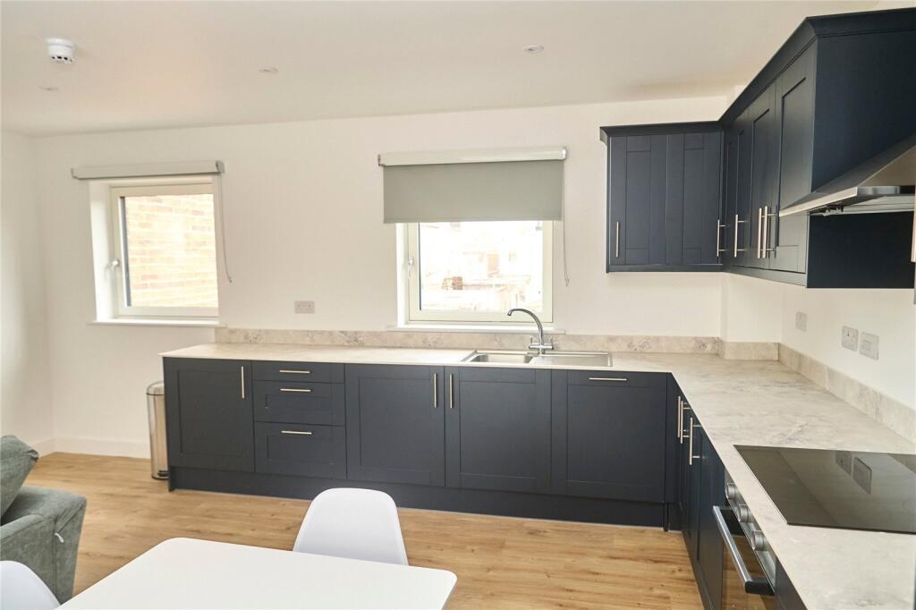 Bright and modern kitchen featuring sleek dark ...