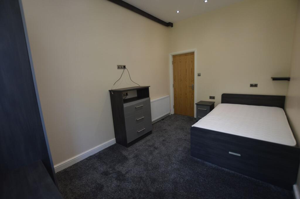 A cozy bedroom with a double bed, a small bedsi...