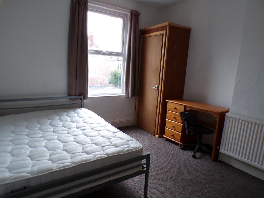 A spacious double bedroom with natural light, p...