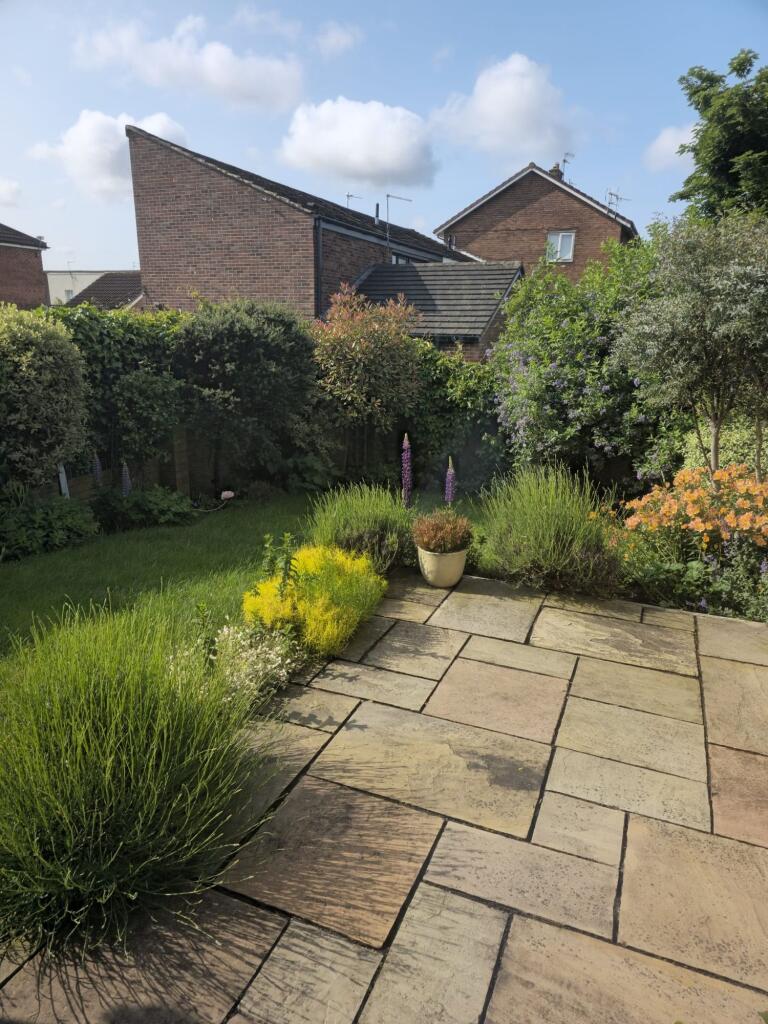 Beautifully maintained garden featuring a spaci...