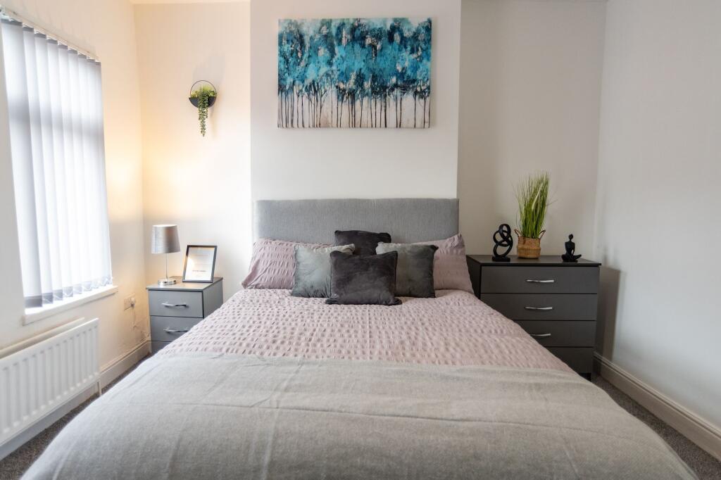 A cozy double bedroom featuring a comfortable b...