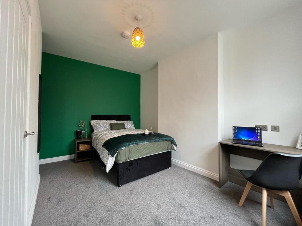 This inviting double bedroom features a cozy be...