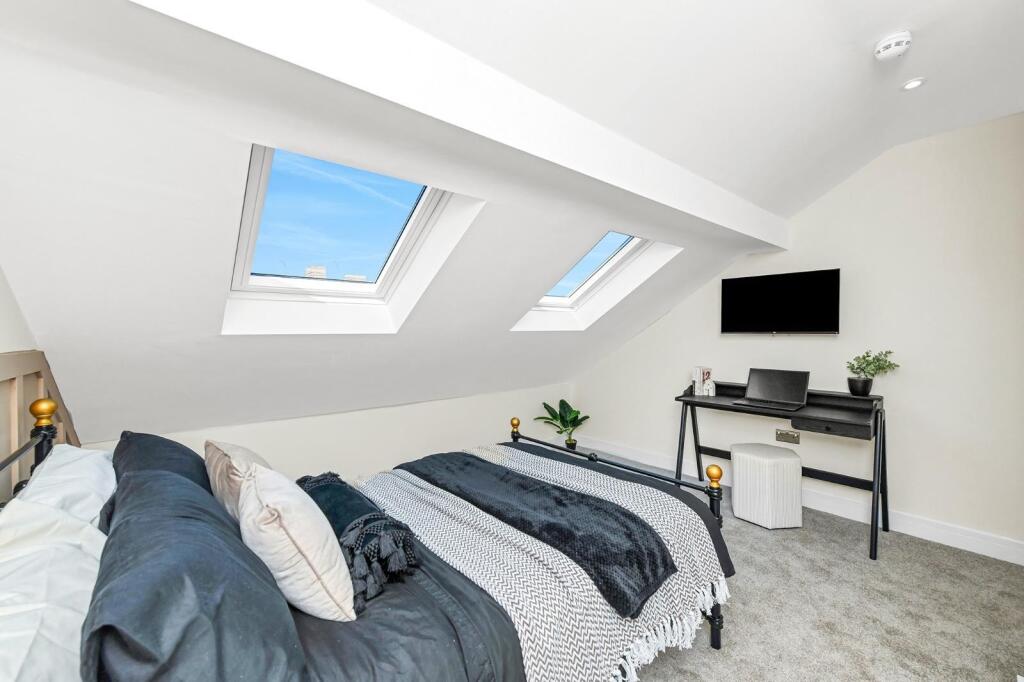 A stylish double bedroom featuring skylights th...