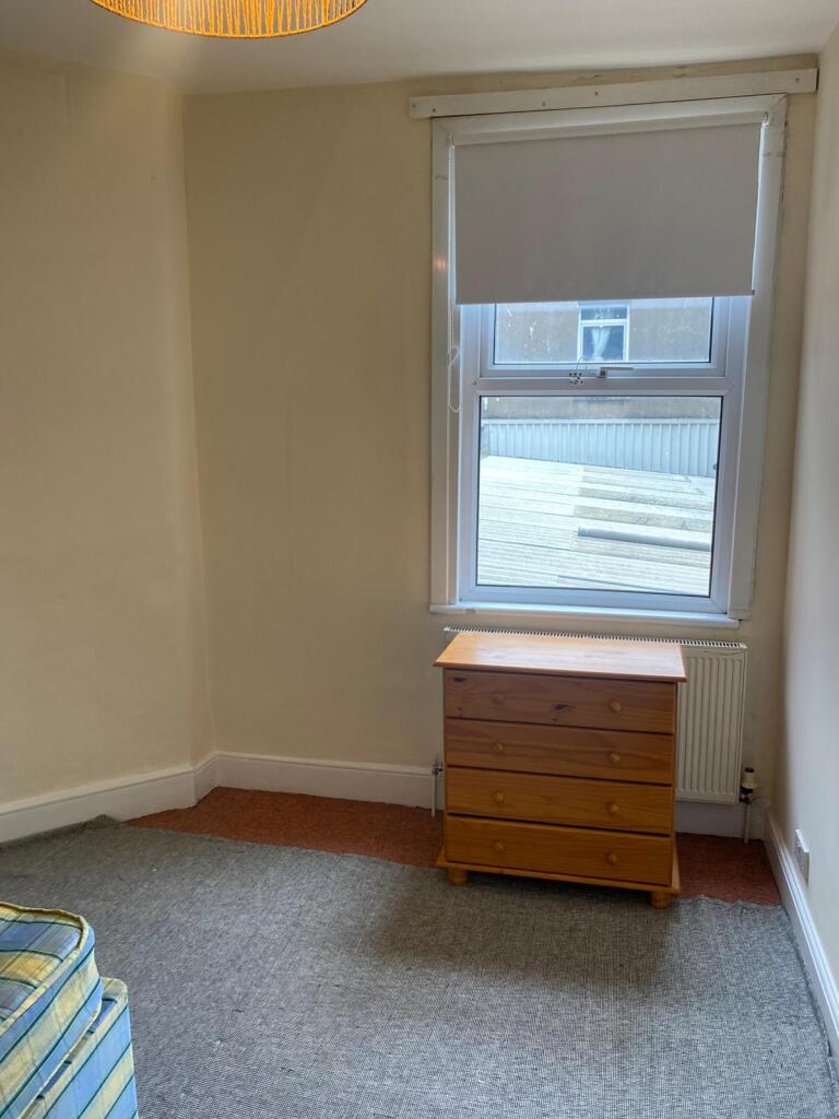 A simple and clean single bedroom featuring a l...