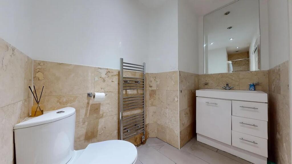 Bright and modern bathroom featuring a white to...