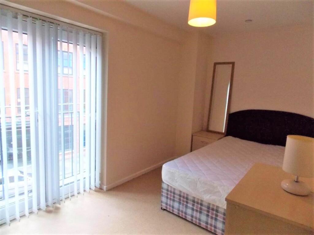 A bright and tidy double bedroom featuring a la...