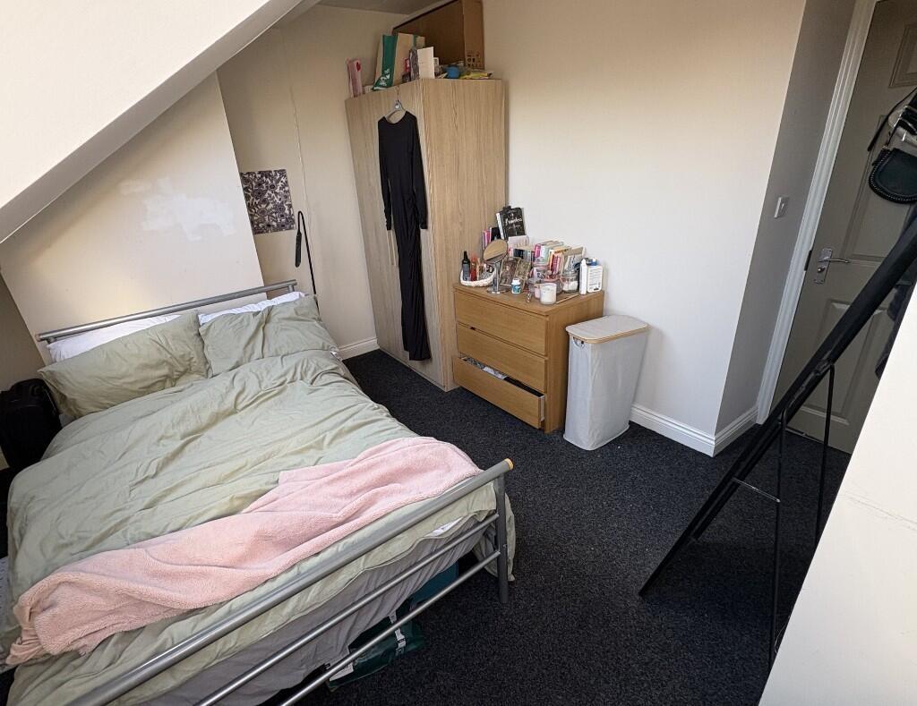 Cozy single bedroom featuring a neatly made bed...