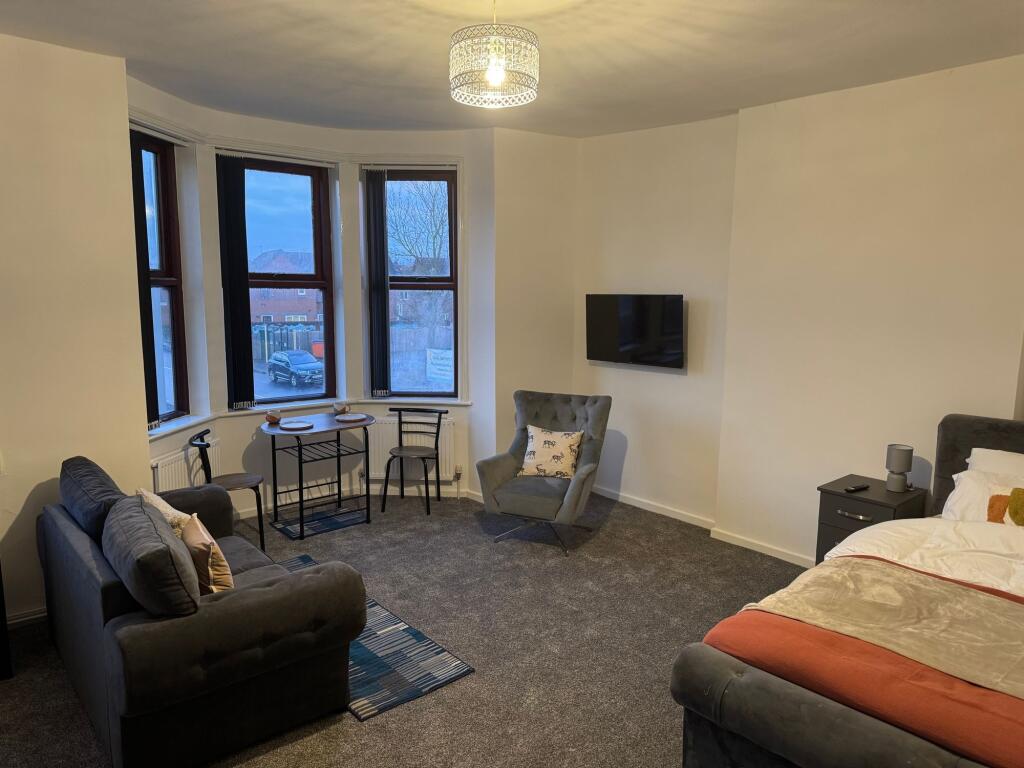 A spacious and inviting master bedroom featurin...