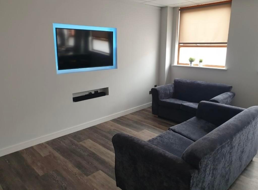 A modern living room featuring dark upholstered...