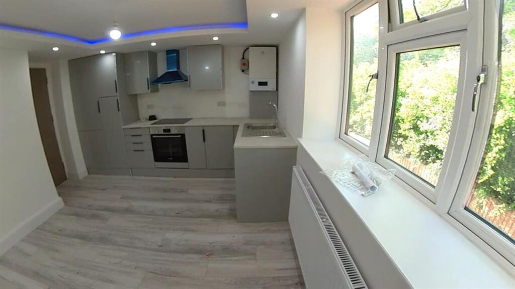 A bright, modern kitchen featuring sleek cabine...