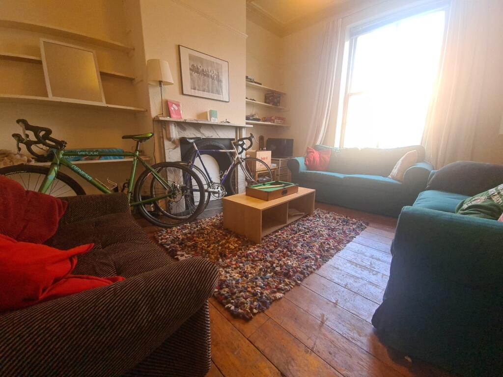 A cozy, well-lit living room featuring comforta...