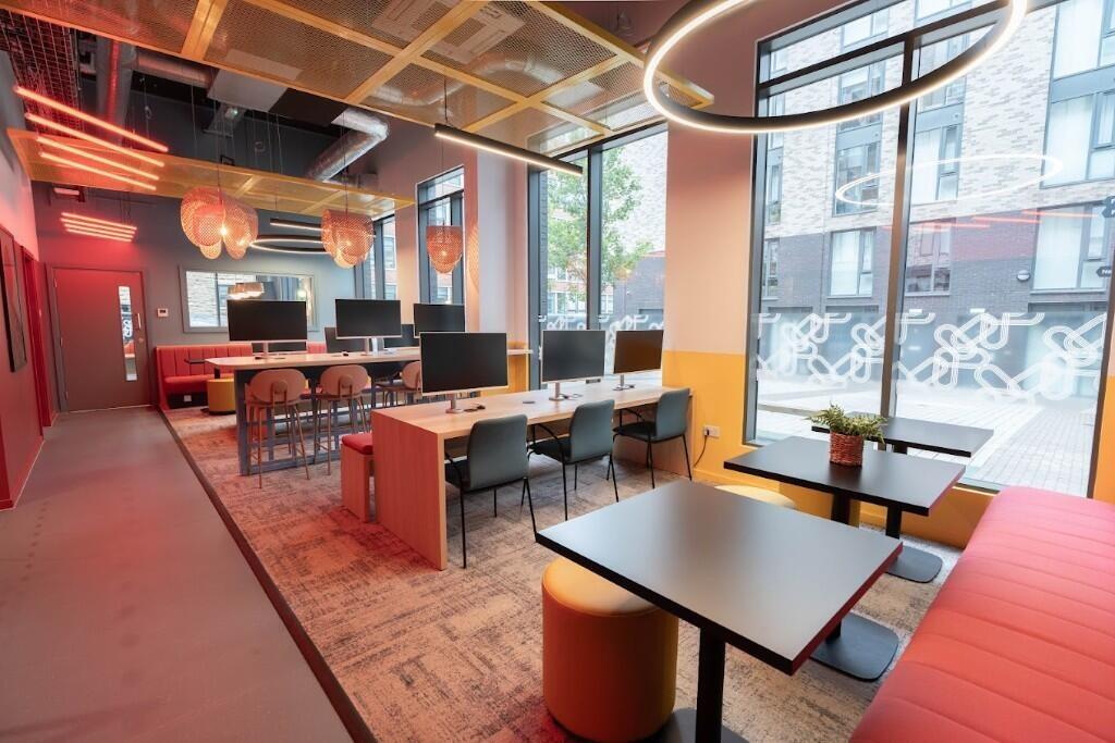 A modern communal workspace featuring multiple ...